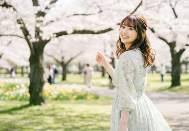 春の気候の良い公園でデートを楽しむ女性のイメージ画像です。