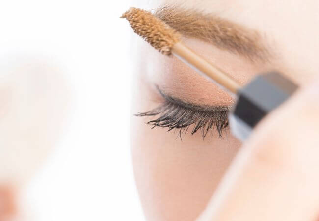 垢抜けのために眉マスカラで眉毛の印象を整える女性のイメージ画像です。