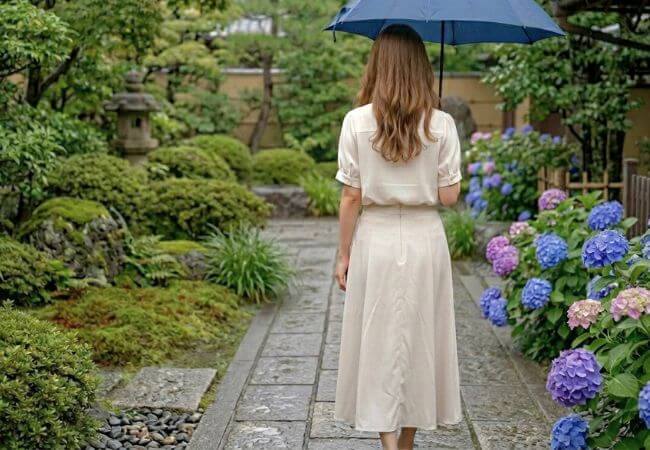 雨の日に傘をさして結婚相談所のお見合いに向かう女性のイメージ画像です。